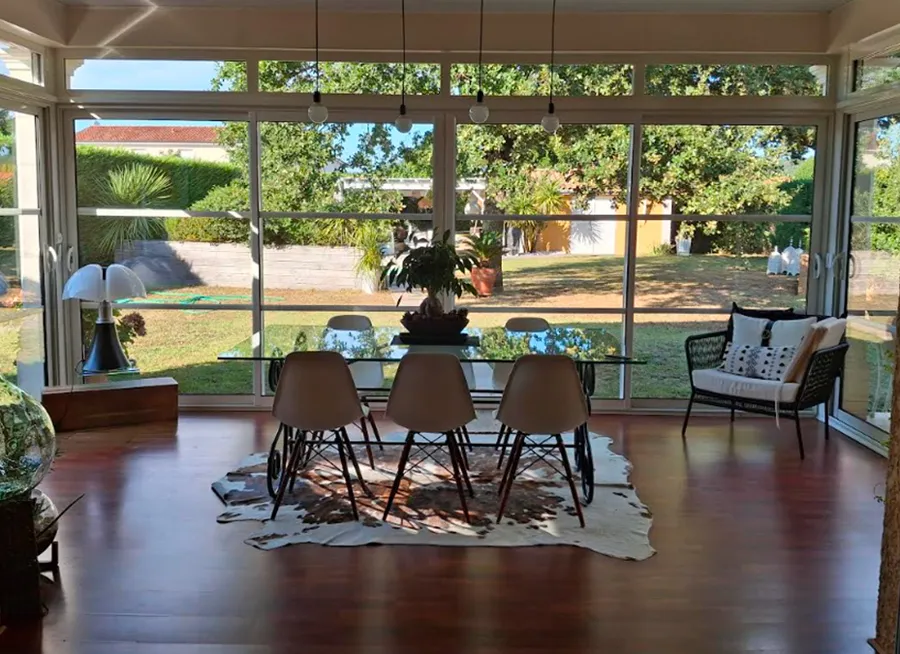Véranda-ardecorhome-1 baie vitree avec table de salon vue sur jardin